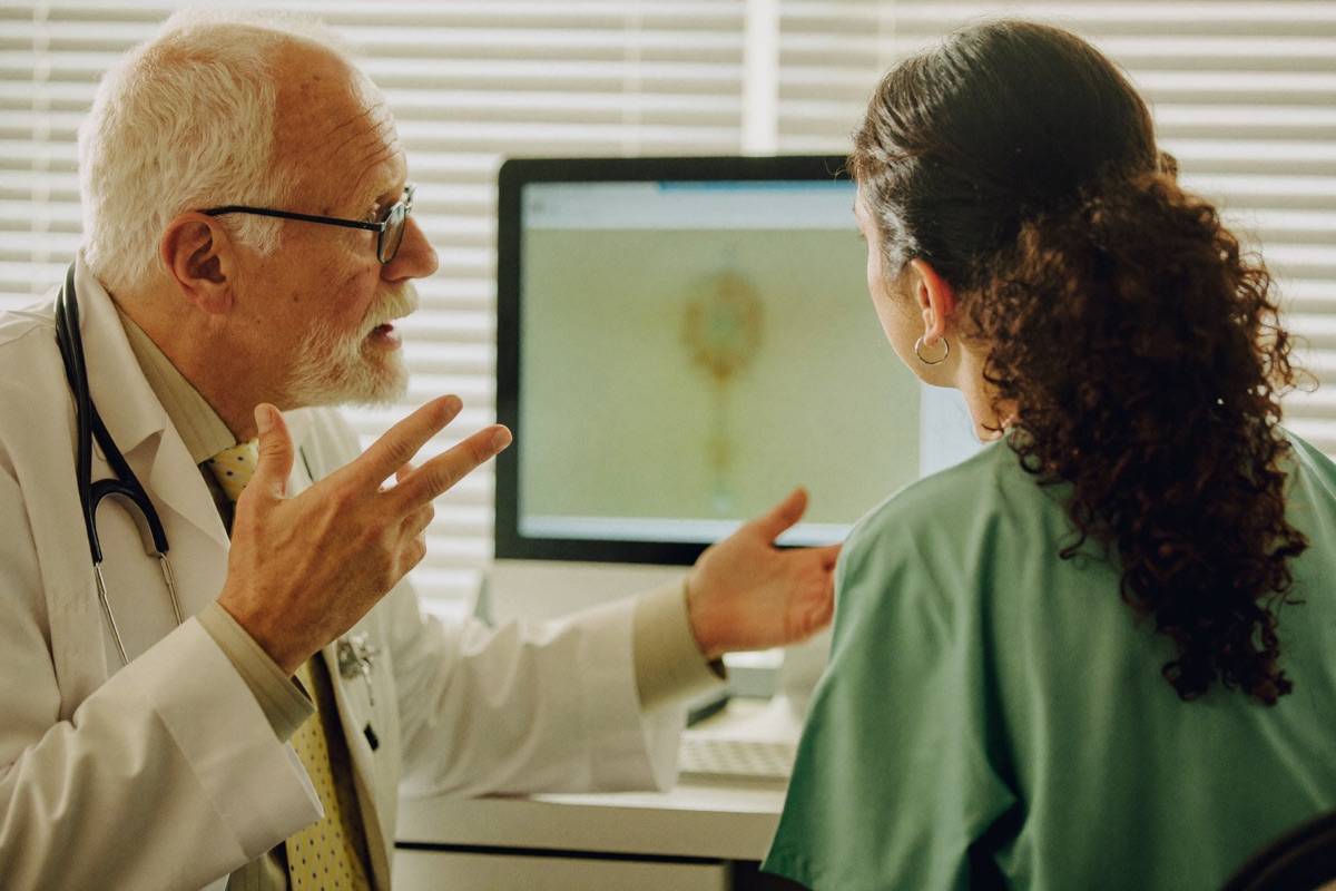 Senior doctor and junior doctor in discussion over a screen